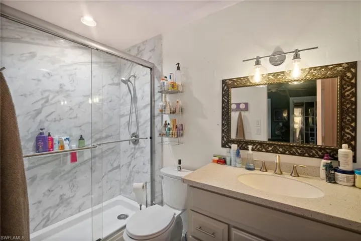 Bathroom with toilet, vanity, and walk in shower
