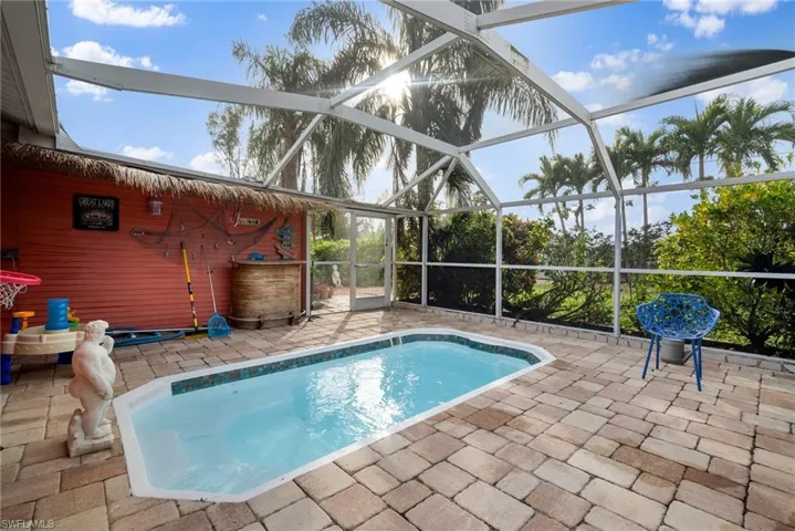 View of pool featuring glass enclosure and a patio area