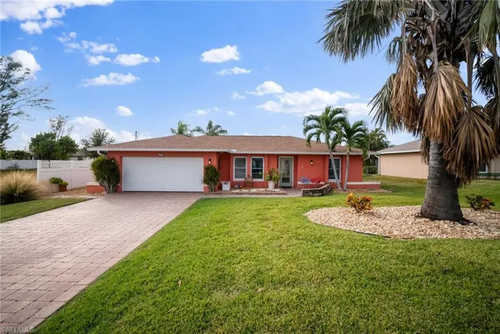 Ranch-style home with a front yard and a garage