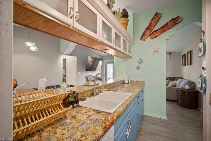 Kitchen featuring blue cabinetry, sink, and dark hardwood / wood-style floors