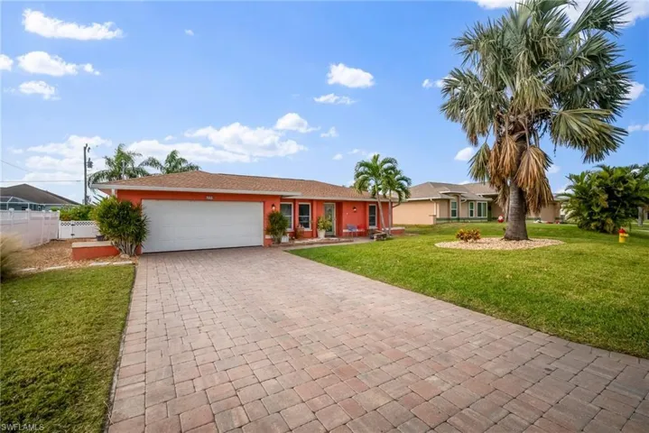 Ranch-style house with a front yard and a garage