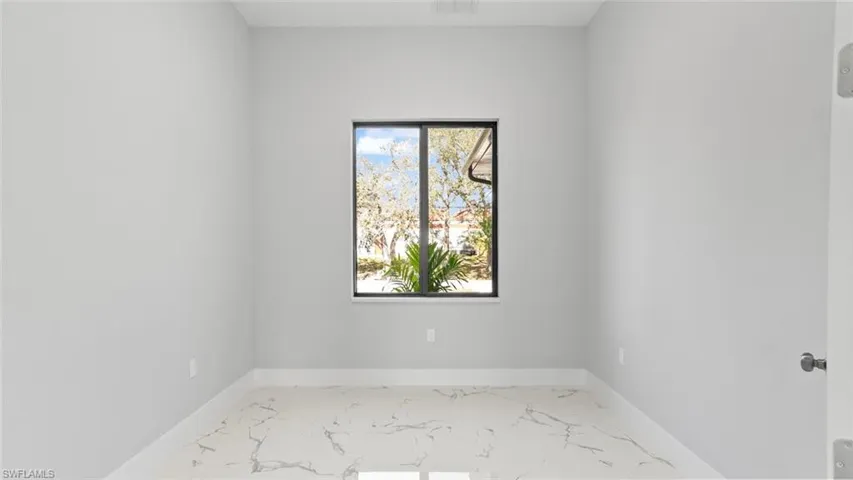 Spare room with marble finish floor and baseboards