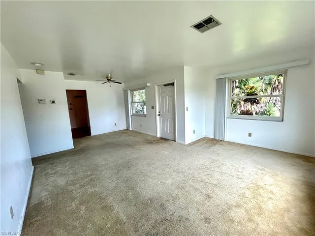 Carpeted spare room featuring ceiling fan