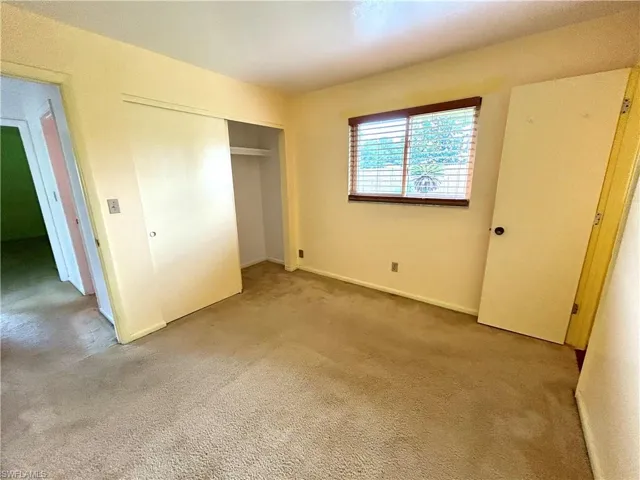 Unfurnished bedroom featuring a closet and light carpet