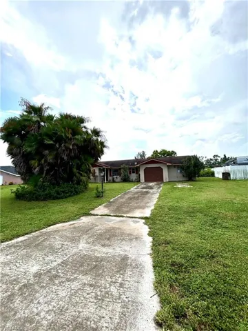 View of front of house with a garage and a front lawn