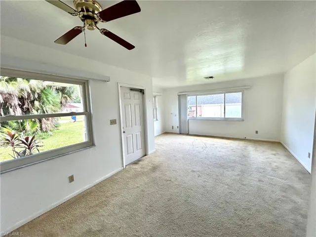 Unfurnished room featuring ceiling fan and light carpet