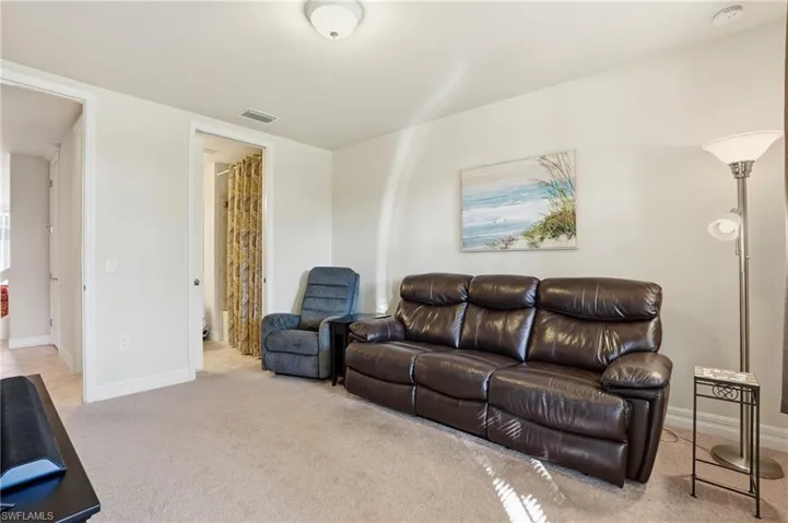 Living area with light carpet and baseboards