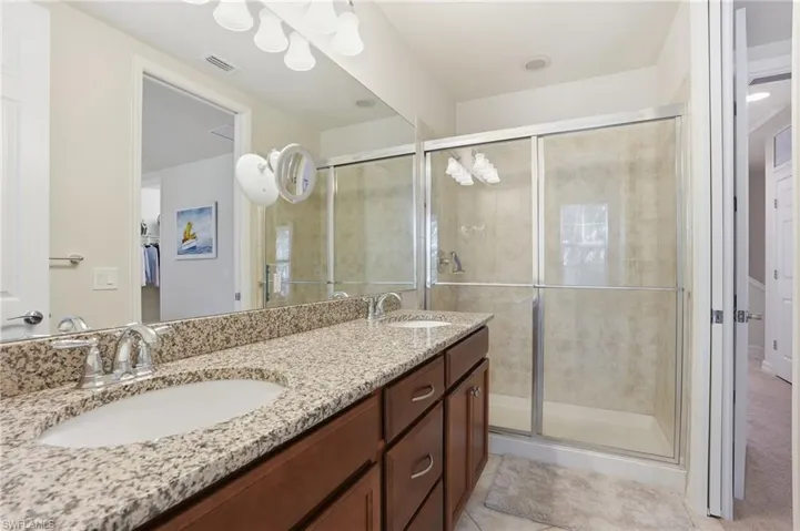 Bathroom featuring double vanity and a shower stall
