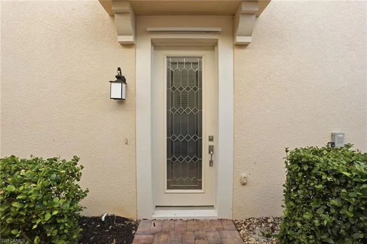 Doorway to property featuring stucco siding