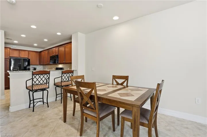 Dining area with recessed lighting and light tile patterned floors