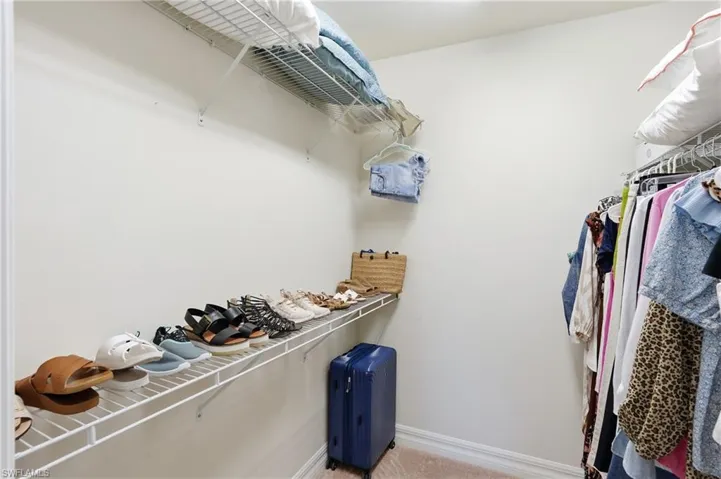 Walk in closet featuring light carpet