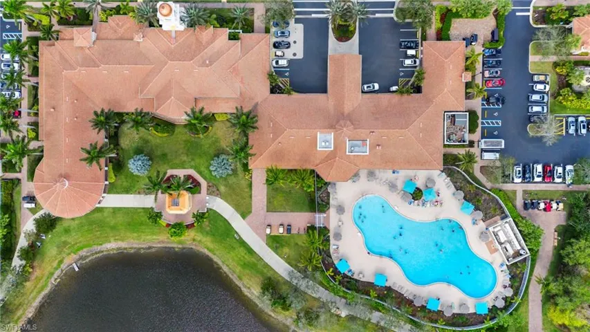 Aerial view of a pool area and a large body of water