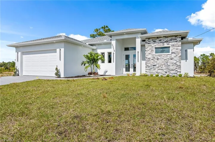 Prairie-style home with a garage, french doors, and a front lawn