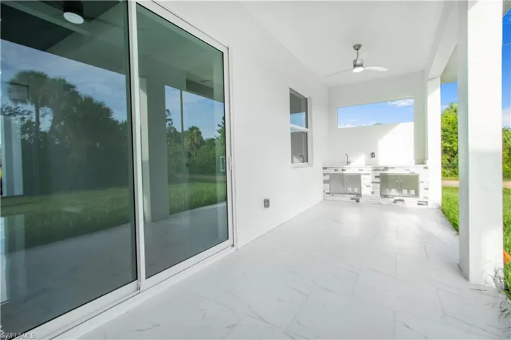 View of patio with exterior kitchen and ceiling fan