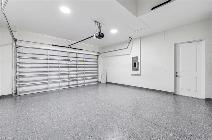 Garage featuring electric panel and a garage door opener