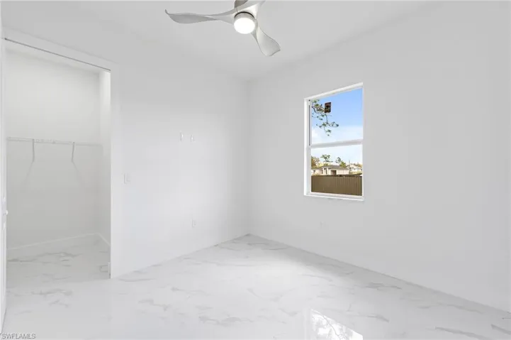 Tiled empty room with ceiling fan