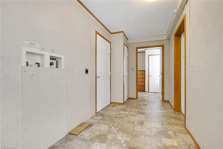 Hallway featuring crown molding and stone finish floors