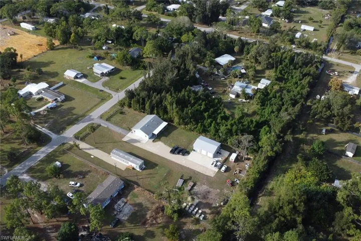 Aerial view of property and surrounding area featuring nearby suburban area
