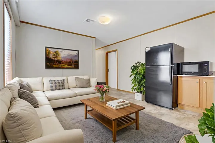 Living area featuring ornamental molding and stone finish floors