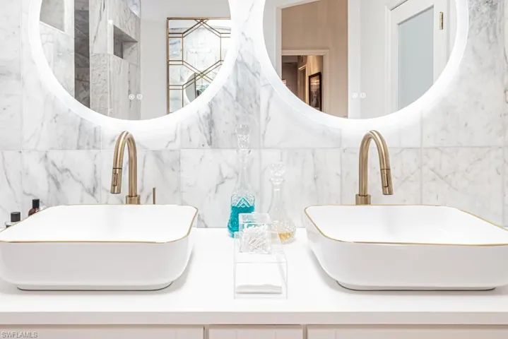 Close up of vanity fixtures and lit mirrors