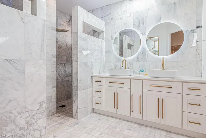 Marble Dual Showers with multi-function shower sprays, designer finishes abound.  Back lit mirrors!