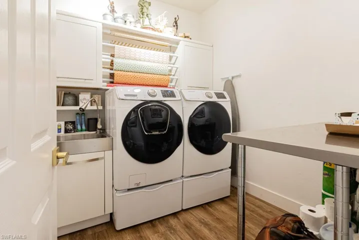 Fully equipped laundry room with sink, work table and gift storage