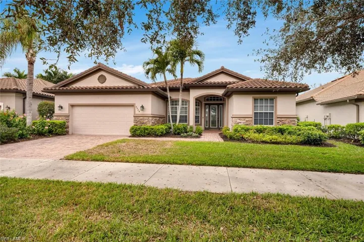 Mediterranean / spanish-style home with a front yard and a garage