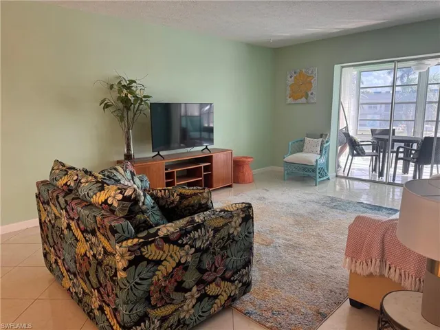 Living room featuring light tile patterned flooring and a textured ceiling