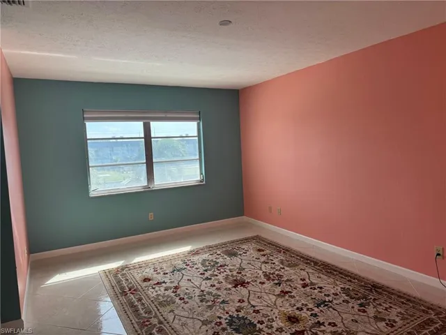 Tiled spare room with a textured ceiling