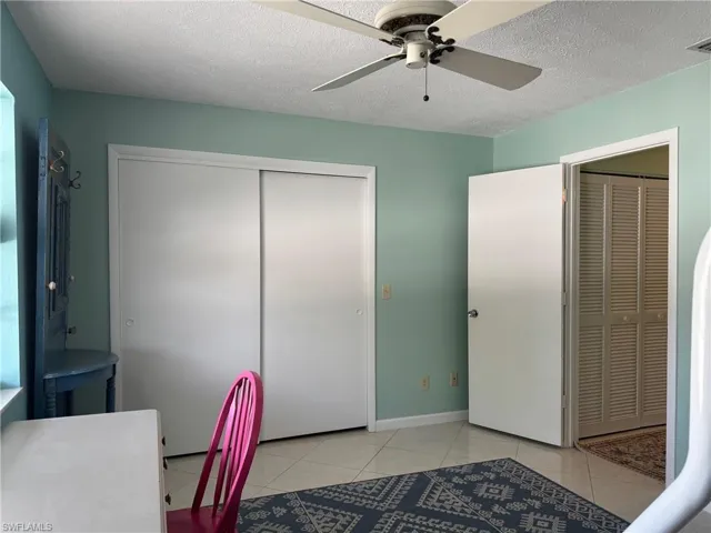 Tiled office featuring a textured ceiling and ceiling fan