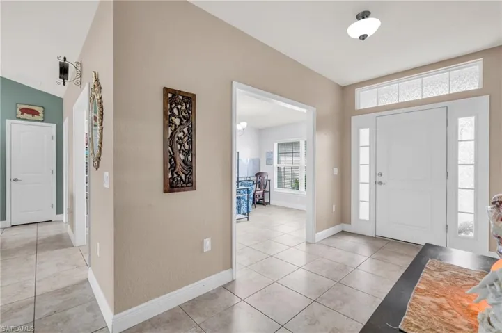 Entrance foyer with baseboards and light tile patterned floors