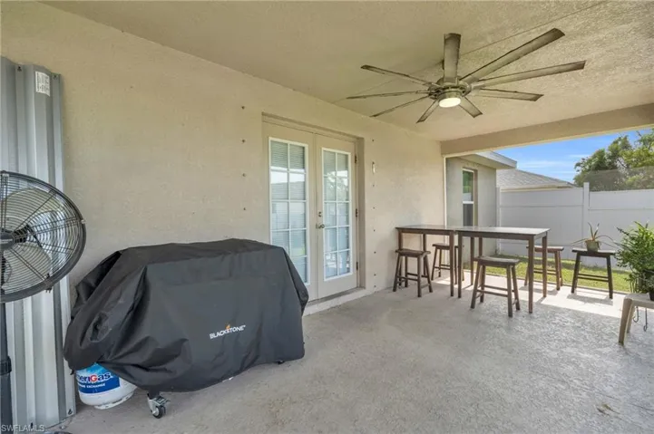 View of patio / terrace with a ceiling fan, french doors, and fence