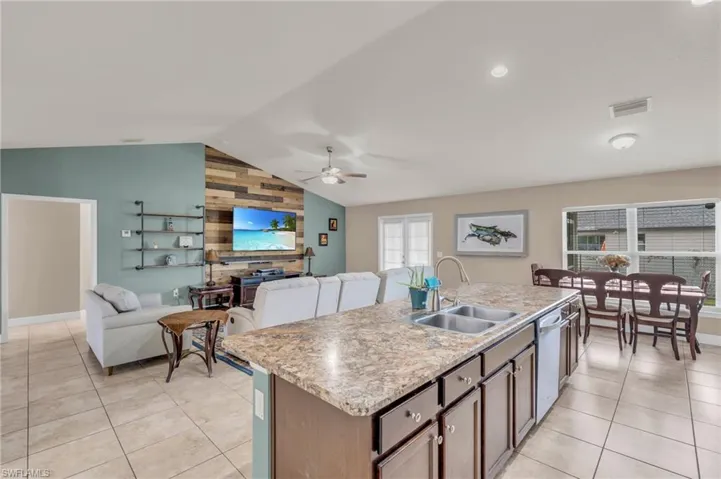 Kitchen featuring a sink, vaulted ceiling, visible vents, ceiling fan, and dishwasher