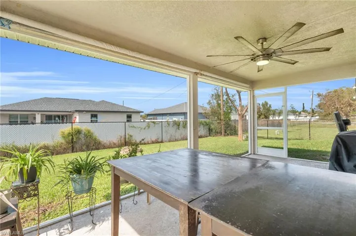 Unfurnished sunroom featuring a ceiling fan