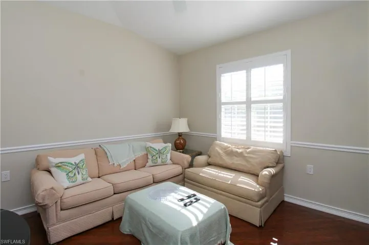 Living room with dark hardwood / wood-style floors and vaulted ceiling