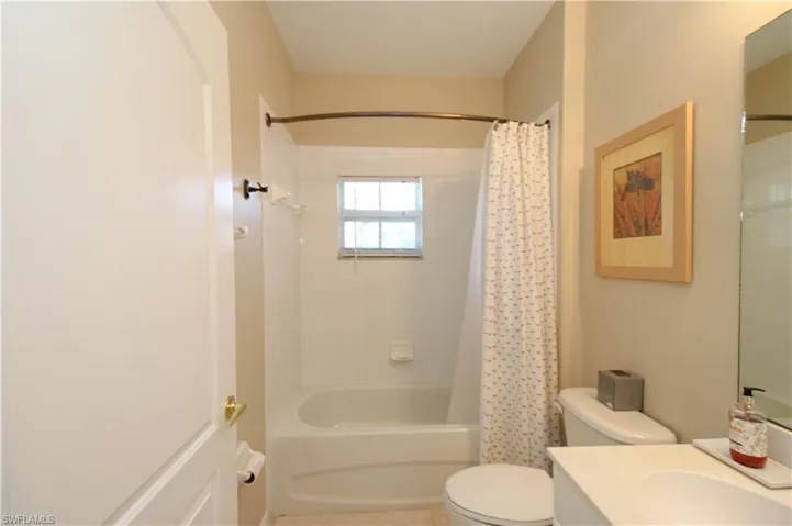 Full bathroom with shower / tub combo, vanity, and toilet