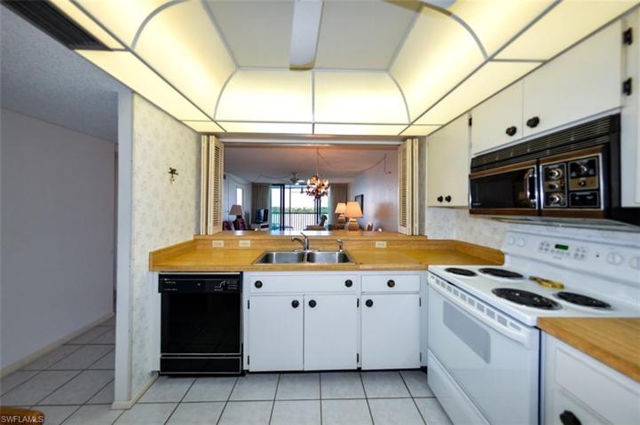 KITCHEN WITH CONVENIENT PASS-THROUGH TO DINING AREA.  ENTRANCE TO GUEST BEDROOM AND GUEST BATH IS TO LEFT.