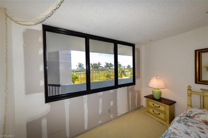 GUEST BEDROOM. SOUTHERN EXPOSURE IMPACT RESISTANT WINDOWS. (ASSOCIATION REPAIRED WALL FROM STORM DAMAGE.)