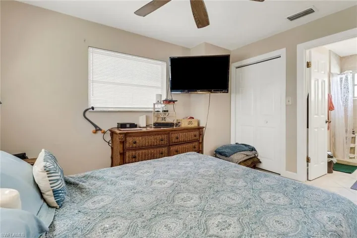 Bedroom with multiple windows, tile patterned floors, a ceiling fan, and a closet