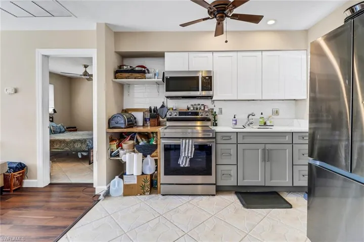 Kitchen featuring a ceiling fan, appliances with stainless steel finishes, decorative backsplash, gray cabinets, and light countertops