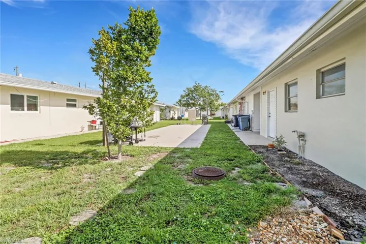 View of grassy yard with a patio area and a residential view