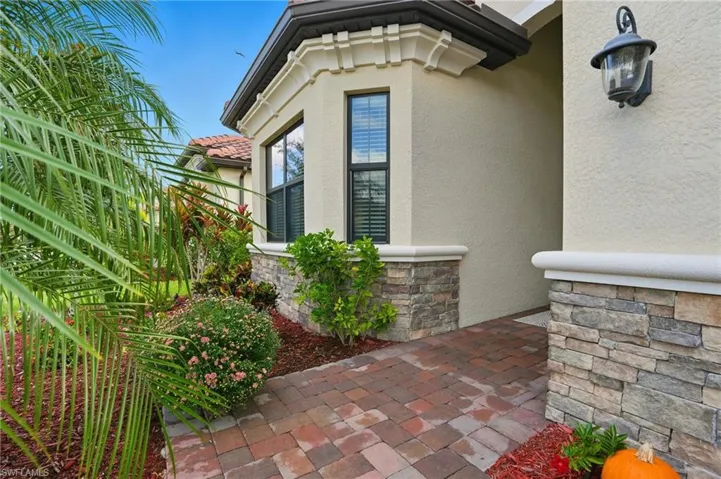 Property entrance with stone siding and stucco siding
