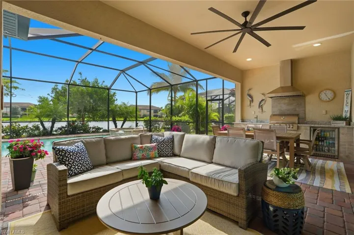 View of patio / terrace with an outdoor kitchen, an outdoor hangout area, wine cooler, a sunroom, and glass enclosure