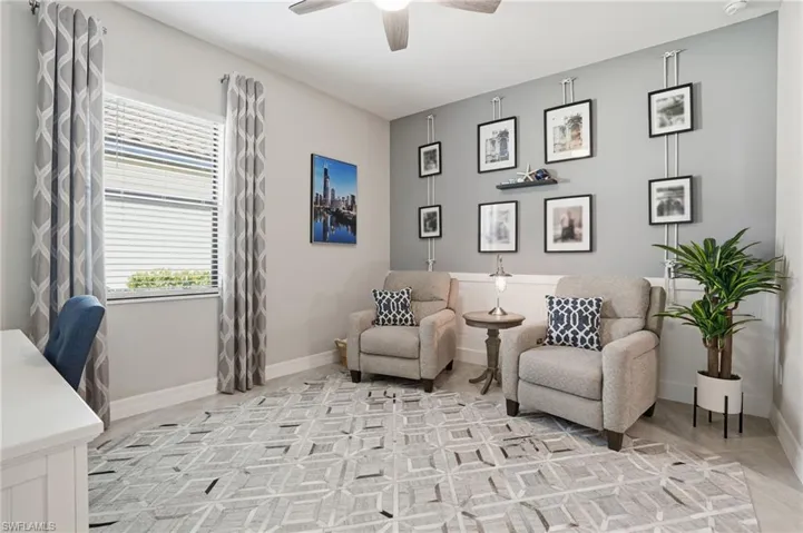 Living area with baseboards and ceiling fan