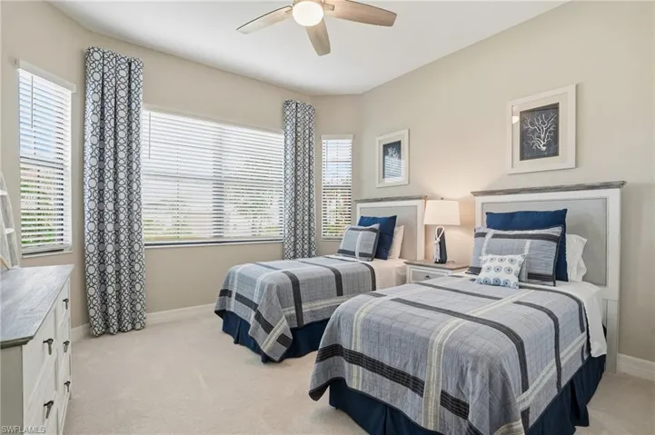 Bedroom with light colored carpet and a ceiling fan