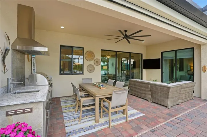 View of patio featuring outdoor dining space, area for grilling, and ceiling fan