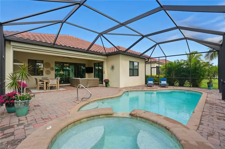 View of pool with a sunroom, a pool with connected hot tub, a patio area, a lanai, and an outdoor living space