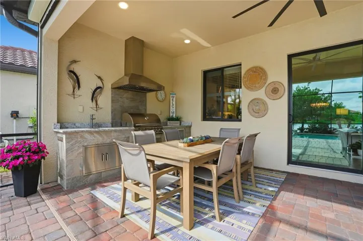 View of patio with outdoor dining space, an outdoor kitchen, and ceiling fan
