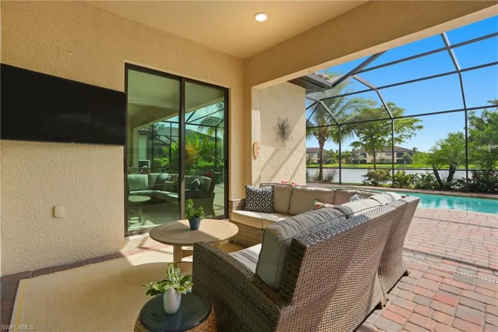 View of patio featuring a sunroom, glass enclosure, an outdoor pool, and an outdoor living space