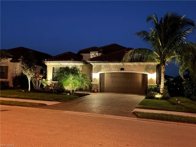 Mediterranean / spanish home featuring stucco siding, decorative driveway, a garage, a tiled roof, and stone siding